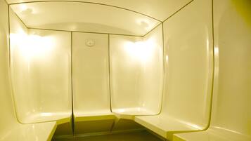 Experience a sleek bathroom with a curved ceiling, recessed light fixture, and smooth walls.