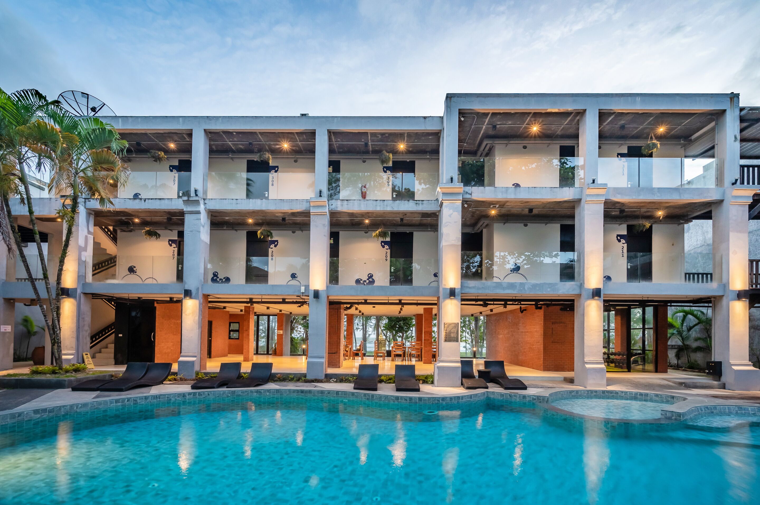 Een hotel met meerdere verdiepingen, een zwembad, terras en modern architectuur.