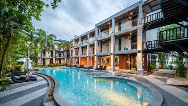 A modern hotel with a swimming pool, outdoor seating, and a multi-story structure. - Kokotel Khao Lak Lighthouse (Takua Pa)