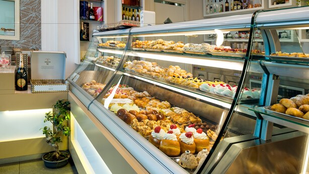 Una vitrina de pastelería con diversos pasteles y postres.