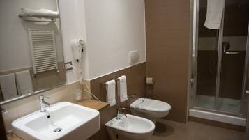 Ein Badezimmer mit Waschbecken, Bidet und einer Duschkabine.