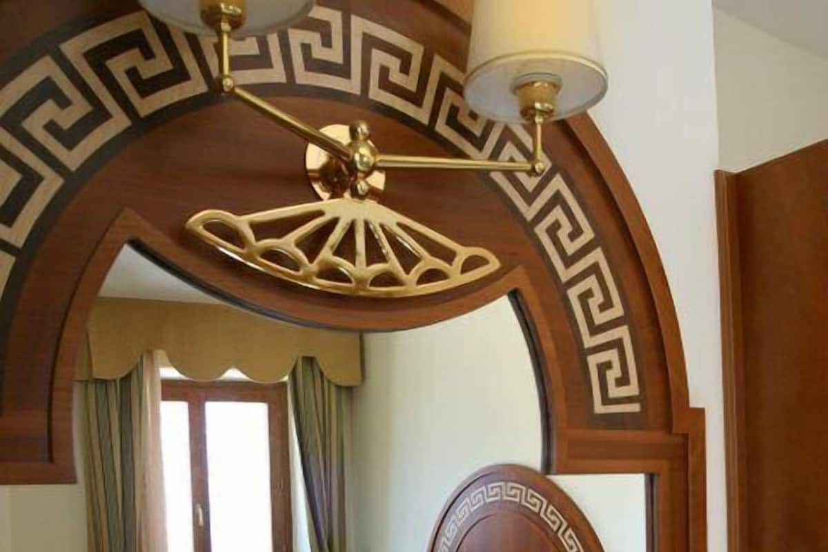 Une chambre à coucher avec un lit, un ventilateur de plafond, une fenêtre avec des rideaux et une plante en pot.