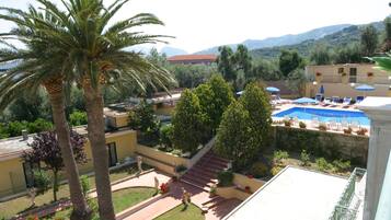 Un área de piscina con sillas de descanso y vistas a las montañas.