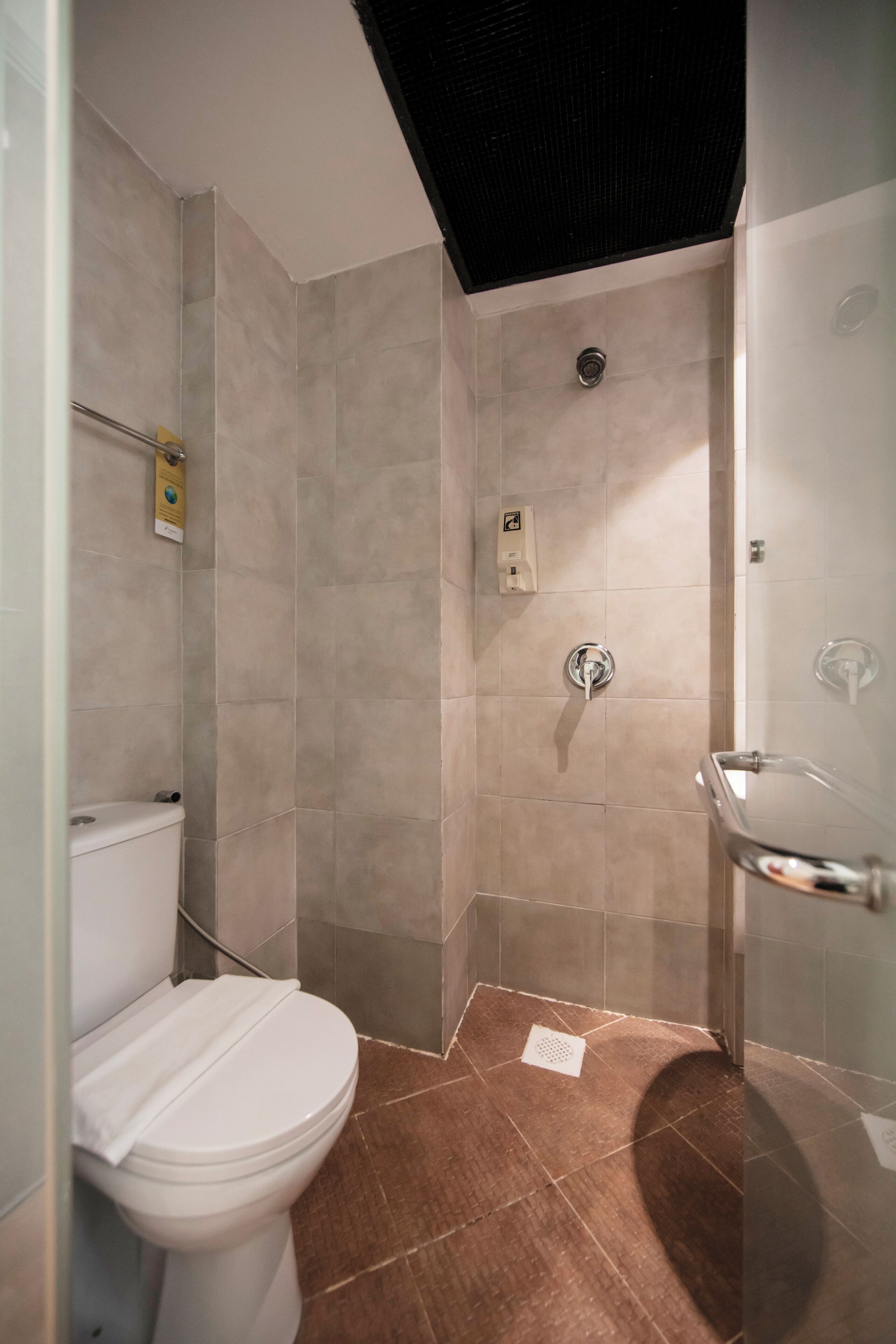 A bathroom with a toilet, shower, and sink.