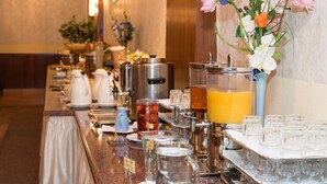 Un buffet proposant une variété de plats et de boissons, notamment une machine à café, une bouilloire et un assortiment de jus de fruits.