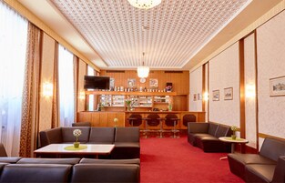 A hotel lobby with leather seating, a bar area, and a television.