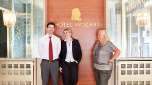 Un espace d’accueil avec un panneau en bois sur lequel est inscrit le nom « HÔTEL MOZART ».