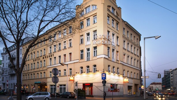 Un hôtel à plusieurs étages, doté d’un dôme imposant et d’une enseigne indiquant « HÔTEL MOZART ».