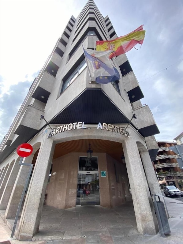 The entrance to the Parthotel Arenteiro, featuring a modern architectural design with a prominent flag and a 'No Entry' sign.