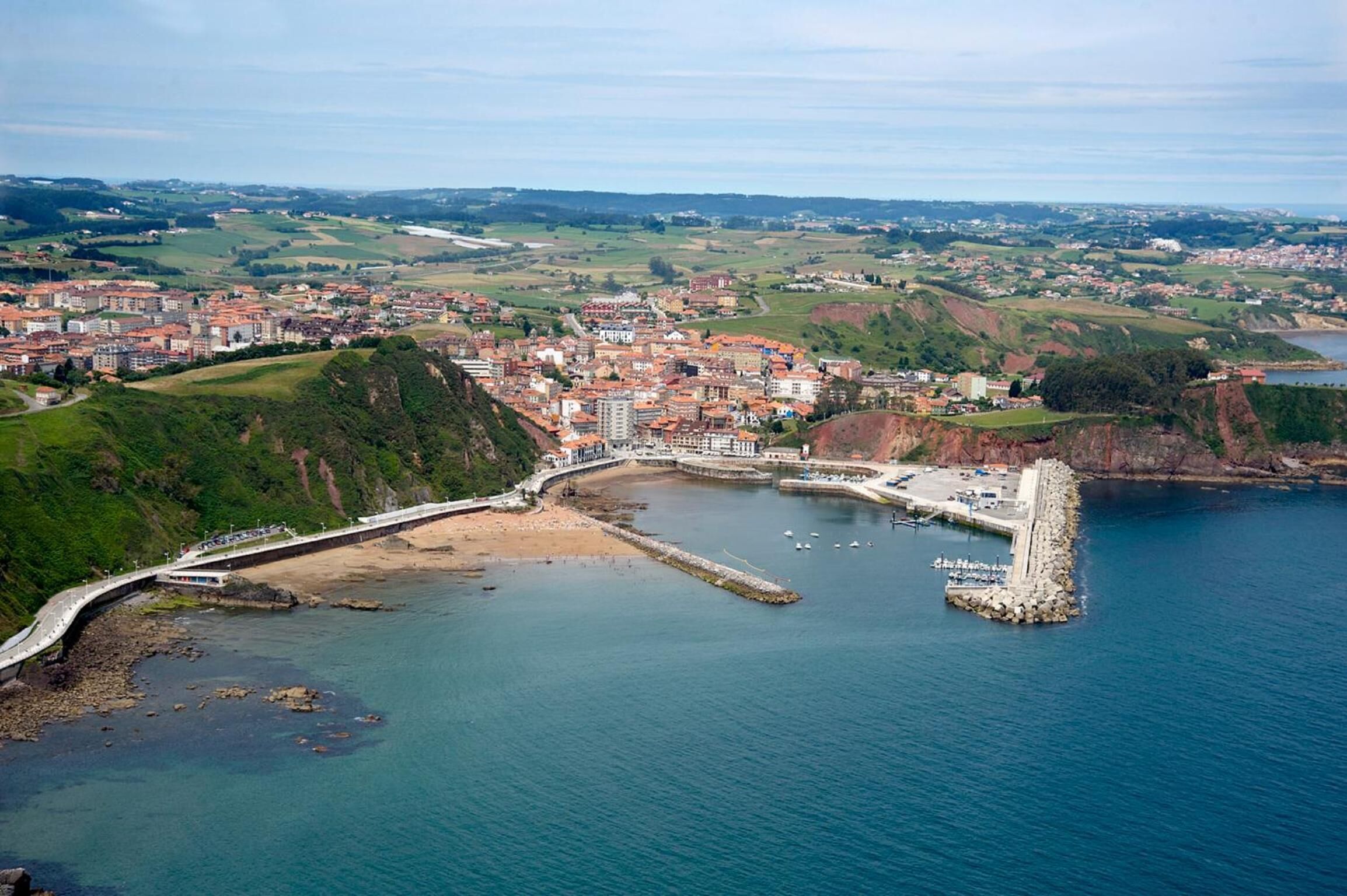 A coastal town with a prominent pier, a bridge connecting to the mainland, and a mix of residential and commercial buildings.