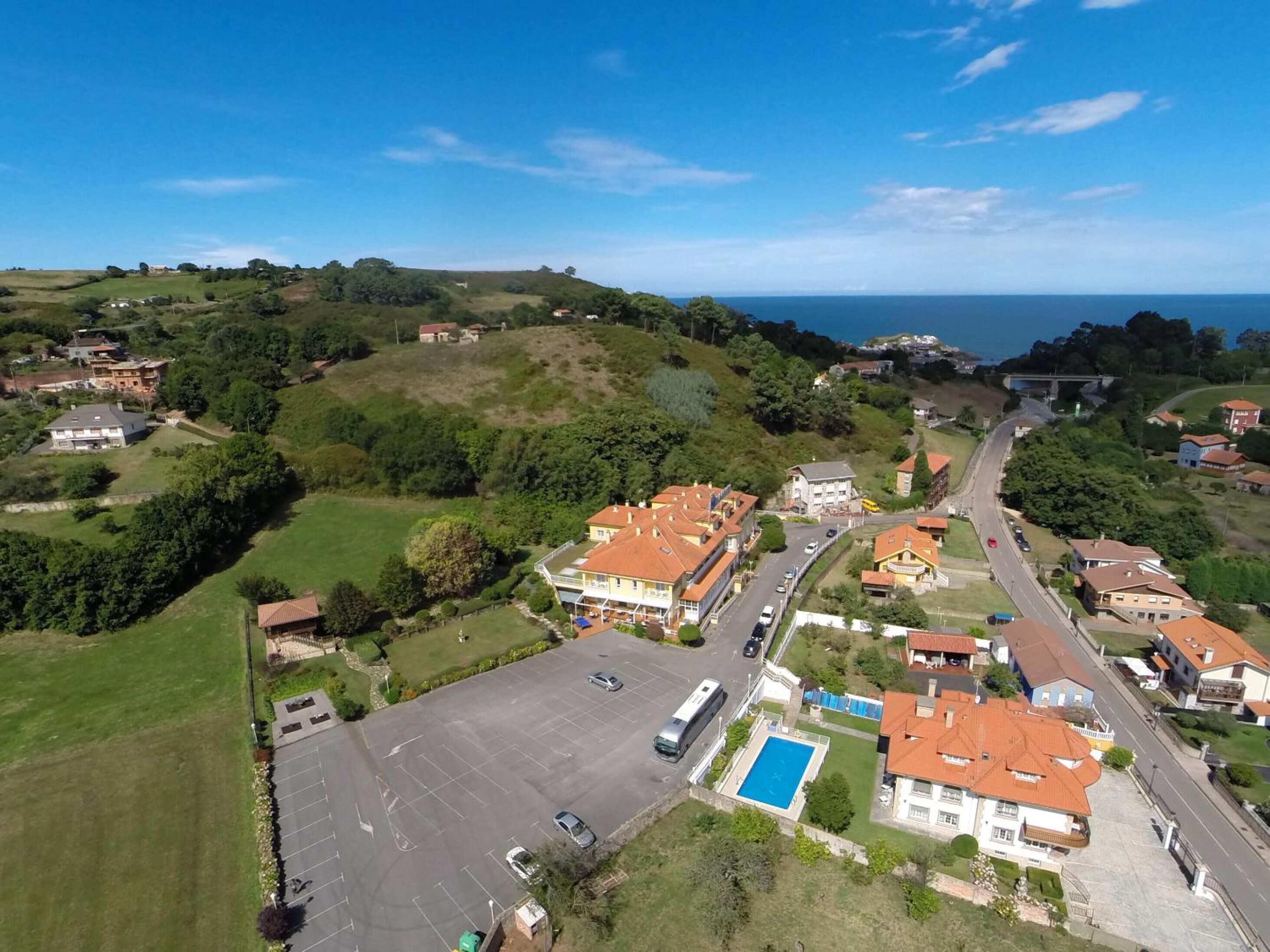 An aerial view of a residential area with houses, a swimming pool, and a road.