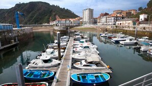 A marina with boats docked, a pier, and buildings in the background. - El Carmen (Carreno)