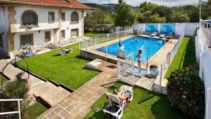 A pool area with a clear blue pool, a small diving board, and a grassy lawn. - El Carmen (Carreno)