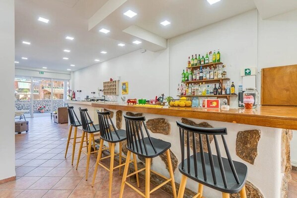 A bar area with stools, shelves of liquor bottles, and a stone wall. - Serdika (Sofia)
