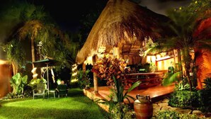 A thatched-roof structure with a dining area and outdoor seating, surrounded by lush greenery. - Hotel Lunata - Near Playa del Carmen Main Beach (Playa del Carmen)