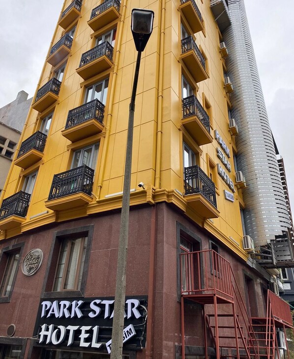 Un edificio amarillo con el letrero del Hotel Park Star.