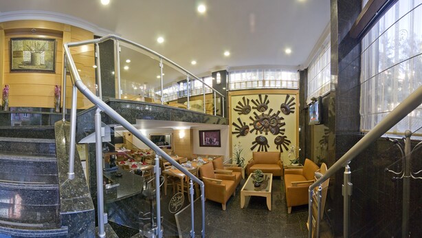 A grand lobby with marble stairs, a seating area with leather chairs, and a decorative wall mural. - Park Star Hotel Taksim (Istanbul)