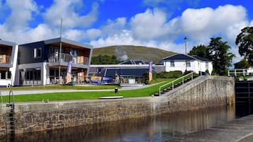 A modern building with a cafe and bistro, a stone wall, and a lock gate.