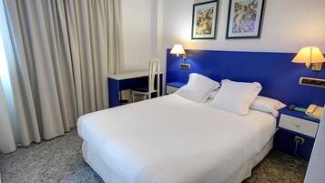 Caja de seguridad en la habitación, escritorio y ropa de cama