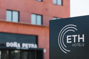 A hotel sign with the name "ETH HOTELS" and a partial view of a building with the name "DORA PETRA" in the background.