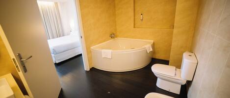A modern bathroom with a bathtub, toilet, and sink.