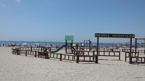 A beach with a children's play area, marked by a sign reading "AREA INFANTIL". - Aguas Salinas (San Pedro del Pinatar)