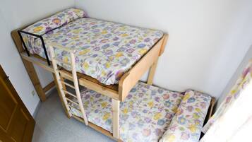Cozy sleeping quarters feature a compact, two-tiered bunk bed with a floral-patterned mattress and metal ladder.