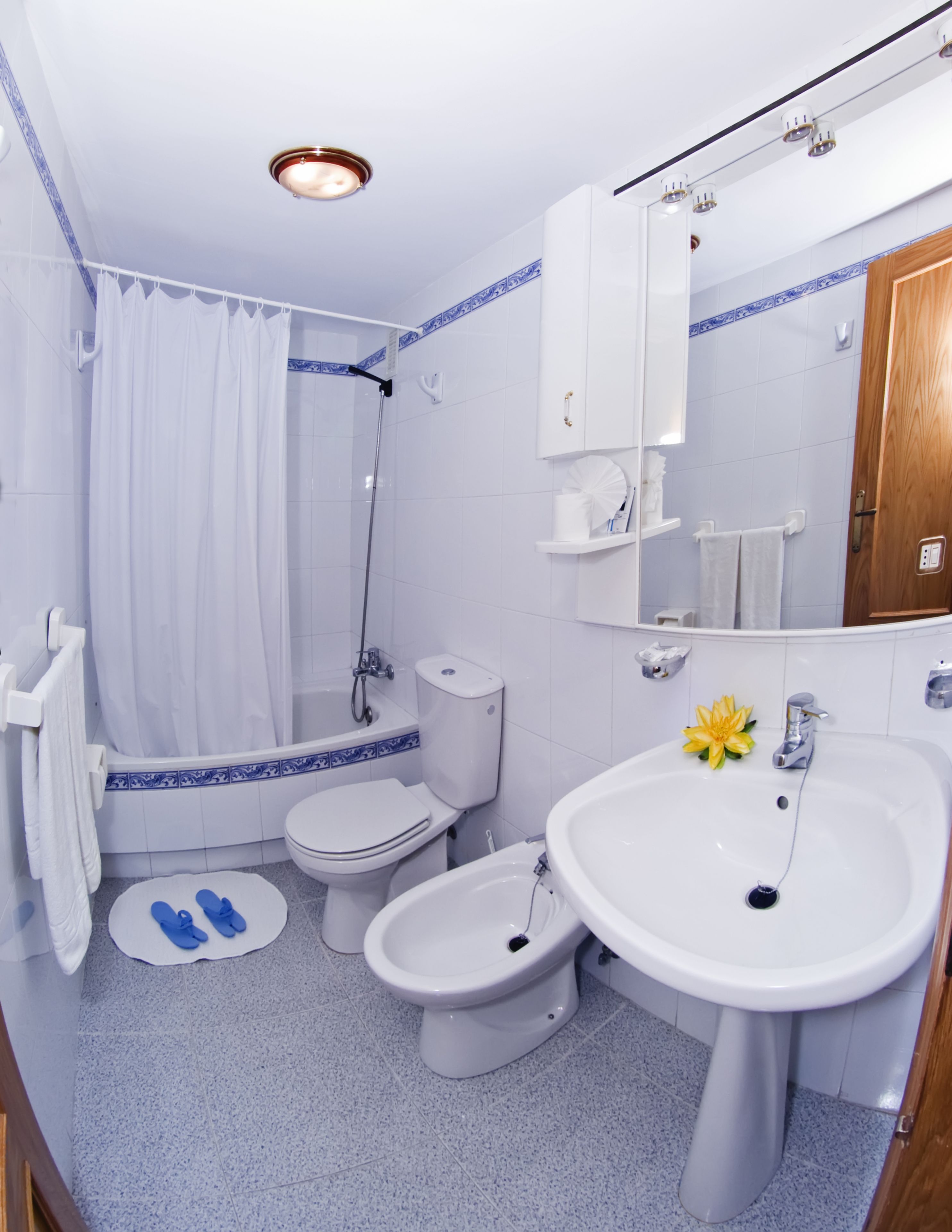 Un baño con ducha, inodoro, bidé y lavamanos.