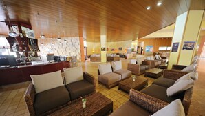 A spacious lounge area with wicker furniture and a bar counter.