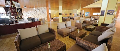 A spacious lounge area with wicker furniture and a bar counter.