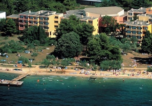 An all-inclusive resort with a sea-side view, featuring multiple buildings and a beach area.