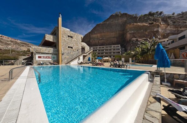 Utomhuspool, parasoller och solstolar