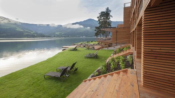 A wooden deck with a view of a lake and mountains. - Seevilla Freiberg (Zell am See)