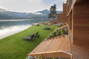 A wooden deck with a view of a lake and mountains. - Seevilla Freiberg (Zell am See)