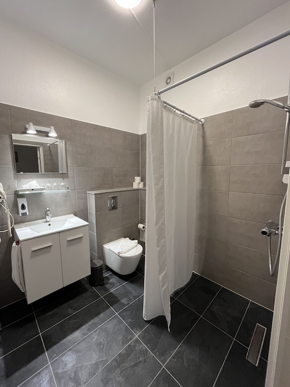 Un baño moderno con ducha, inodoro y lavamanos.