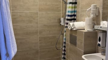A bathroom with a shower, toilet, and sink.