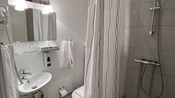 Un baño moderno con ducha, inodoro y lavamanos.