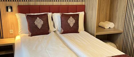 Ein Hotelzimmer mit einem Bett, einem Holzschrank und einem Nachttisch mit Lampe.