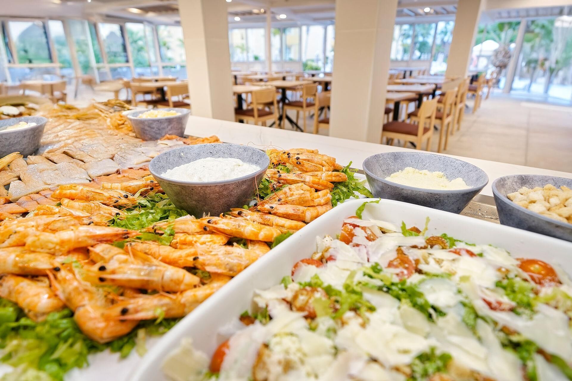 Un bufé con camarones, ensaladas y diversas salsas.