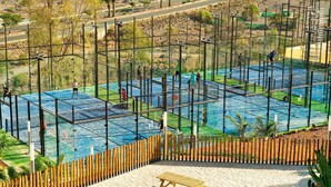 A sports facility with multiple courts, a wooden fence, and picnic tables. - Sport Hotel Monte Feliz - powered by Playitas (San Bartolomé de Tirajana)