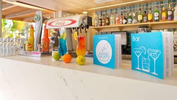 A bar area with a Coca-Cola branded machine, a variety of drinks, and a selection of snacks and bar items.