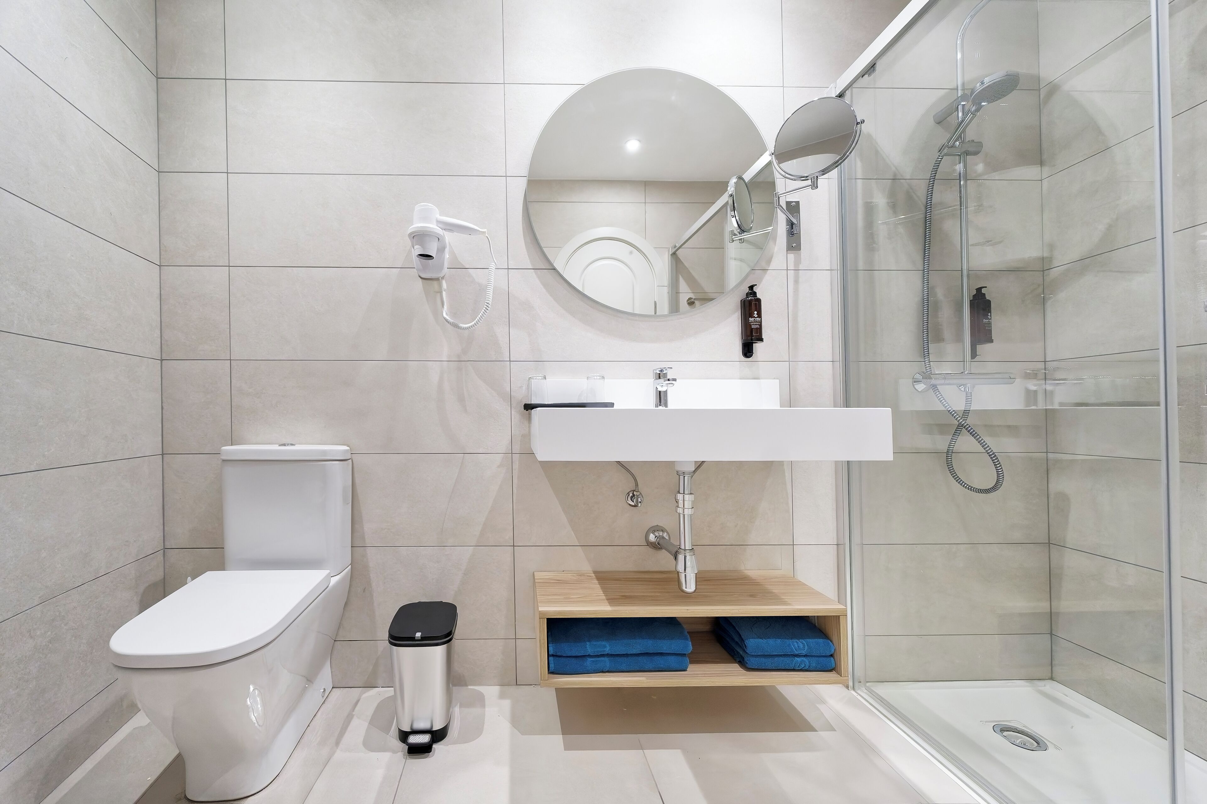 A modern bathroom with a toilet, sink, and shower.