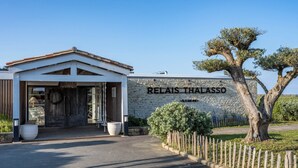 Un bâtiment doté d’un mur en pierre et d’une enseigne sur laquelle on peut lire « RELAIS THALASSO ».