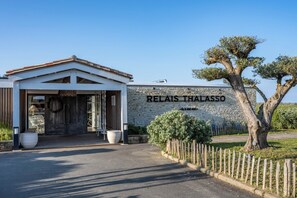 Un edificio con pared de piedra y un cartel que dice 'RELAIS THALASSO'.