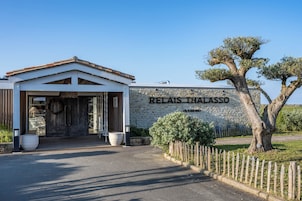 Un bâtiment doté d’un mur en pierre et d’une enseigne sur laquelle on peut lire « RELAIS THALASSO ».