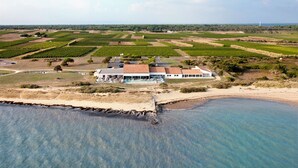 A coastal property with a large house, a swimming pool, and vineyard fields. - Relais Thalasso île de Ré - Hôtel Atalante (Sainte-Marie-de-Re)