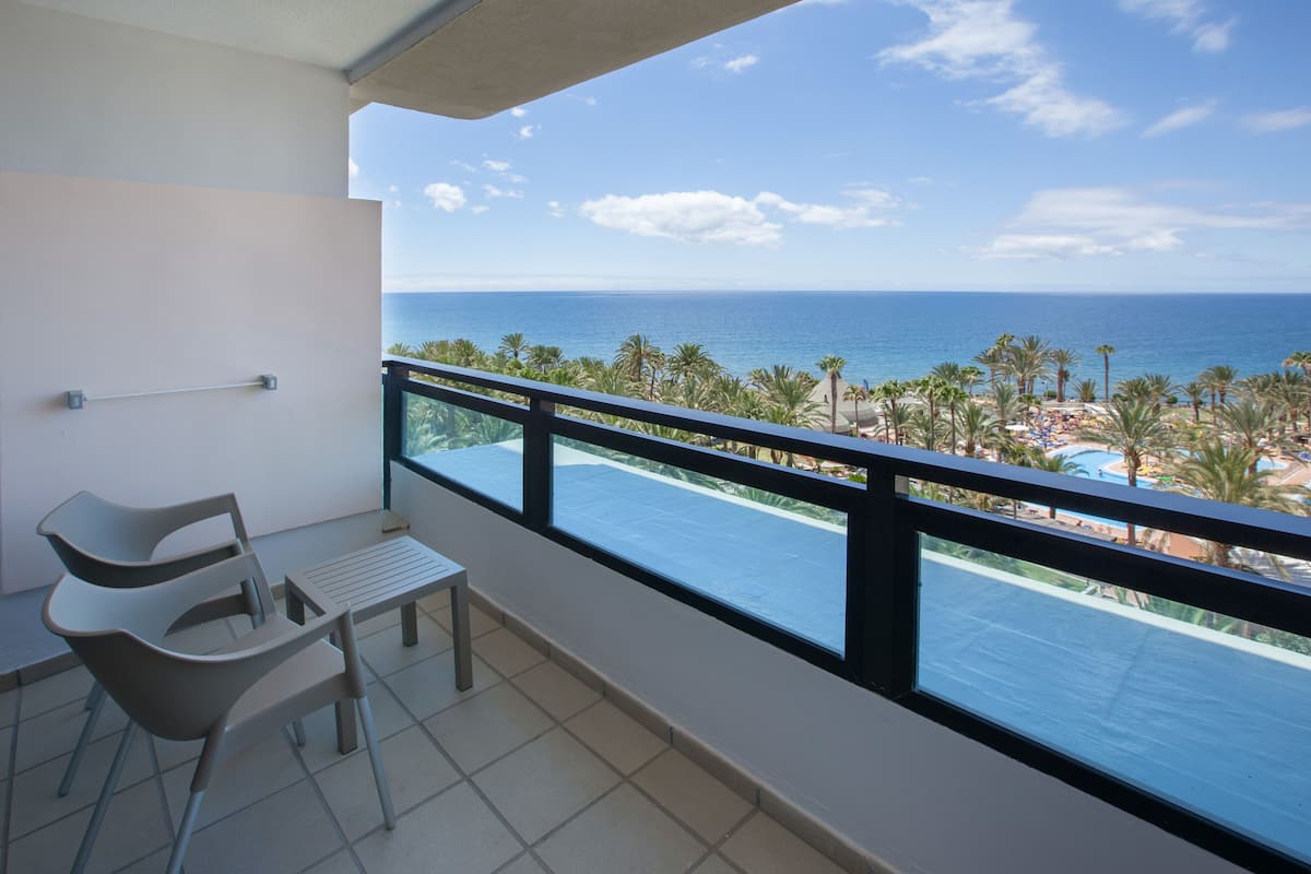 Un balcon avec vue sur l’océan et un espace piscine.