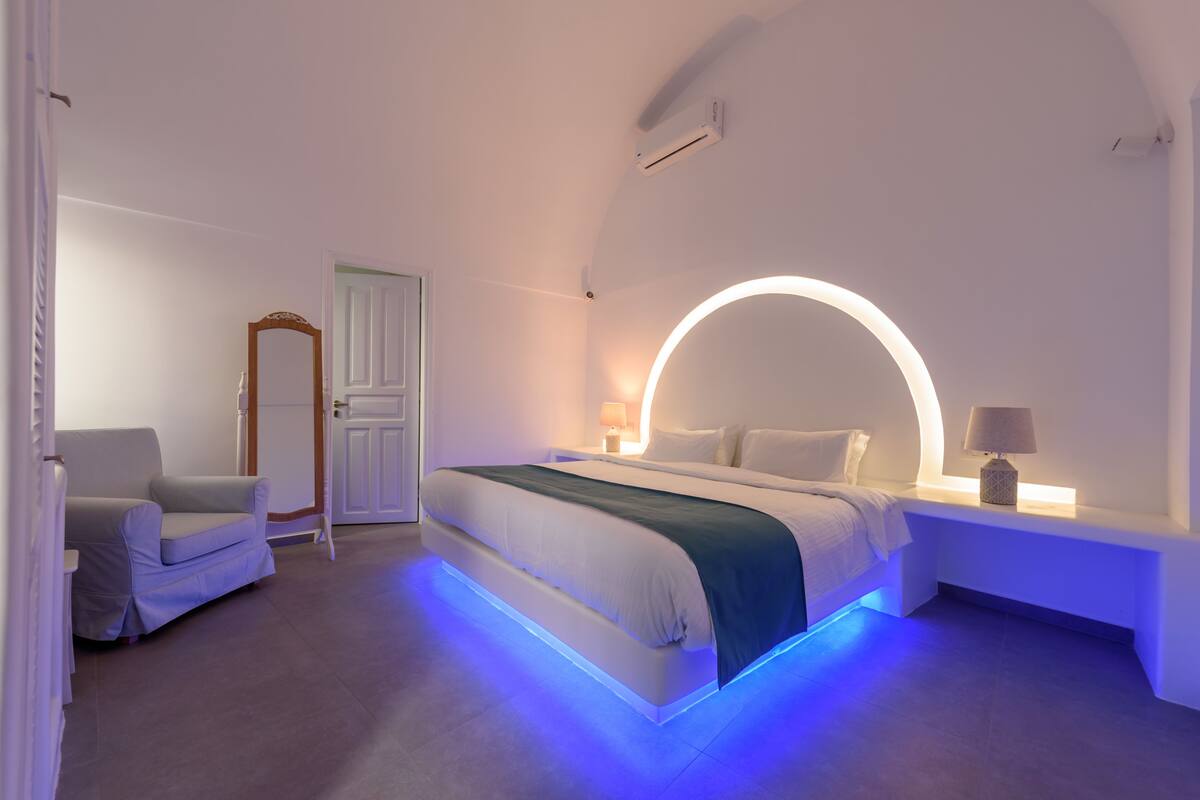 A modern bedroom with a bed, bedside table, and a chair.