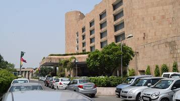 Guests can park their vehicles in the adjacent lot, surrounded by lush greenery and the building's modern design.