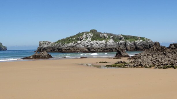 A beach with a rocky outcrop and a small hill. - Hotel Los Juncos (Noja)